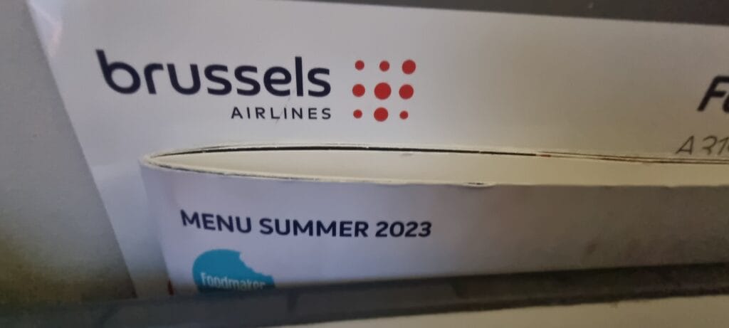 Summer 2023 menu displayed in the seat pocket on a short-haul flight from Brussels to Manchester.