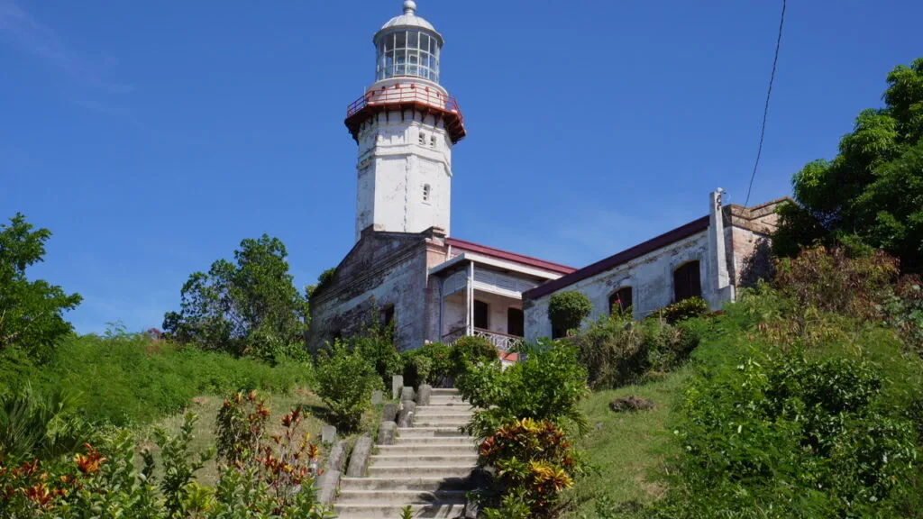Cape Bojeador Lighthouse standing on a hillside in Ilocos Norte, Philippines, viewed from the lower path.