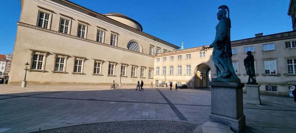 Open square at Christiansborg Palace in Copenhagen with neoclassical buildings