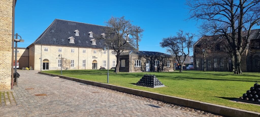 Louis Poulsen building in a courtyard in Copenhagen with historic brick architecture and green lawn
