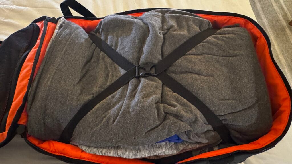 Inside view of hybrid 30L backpack showing orange lining and internal mesh organiser pockets