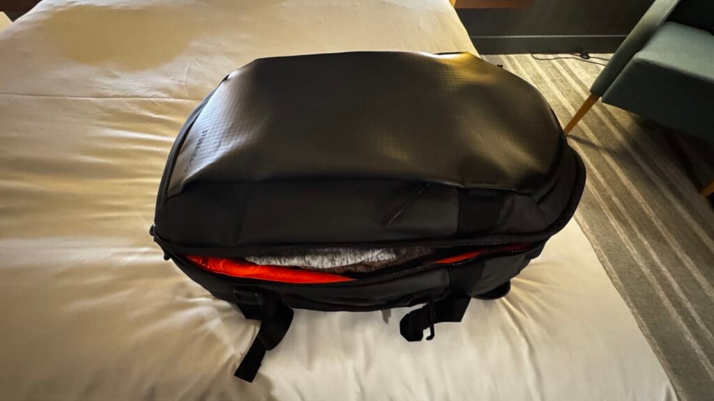 Top view of a fully packed Stubble and Co 30L hybrid backpack resting on a hotel bed before closing