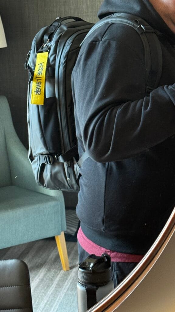 Person wearing a Stubble and Co backpack indoors showing fit, profile, and shoulder strap comfort