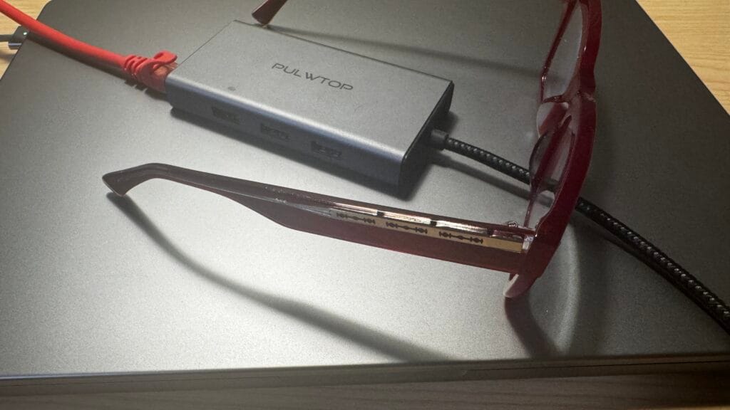 Unique funky glasses frames in translucent red acetate folded on a MacBook laptop