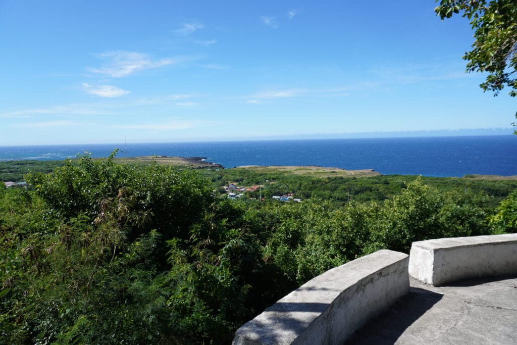 View across the South China Sea from Cape Bojeador Lighthouse in Ilocos Norte, looking inland over coastal vegetation.