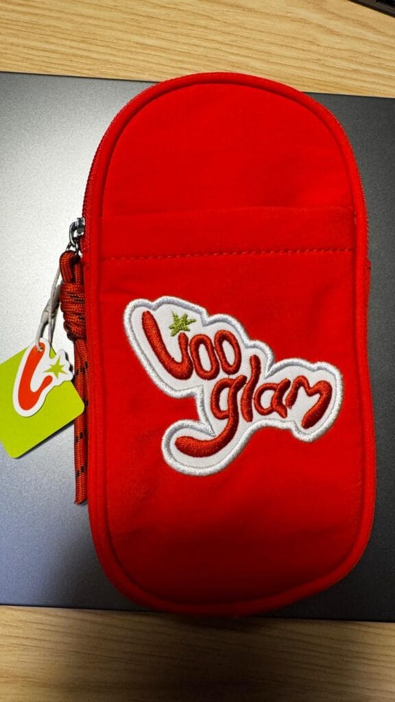 Front of the red Vooglam crossbody phone bag with logo and front pocket.