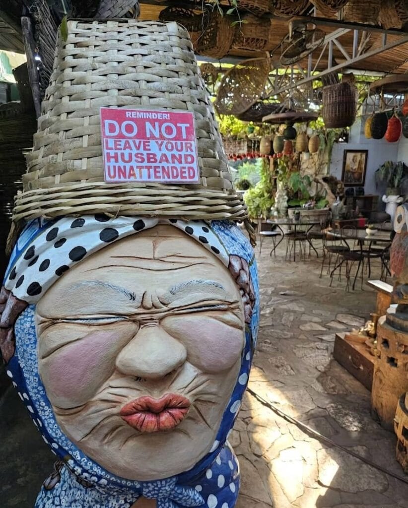 Humorous statue with sign at Hidden Garden in Vigan City