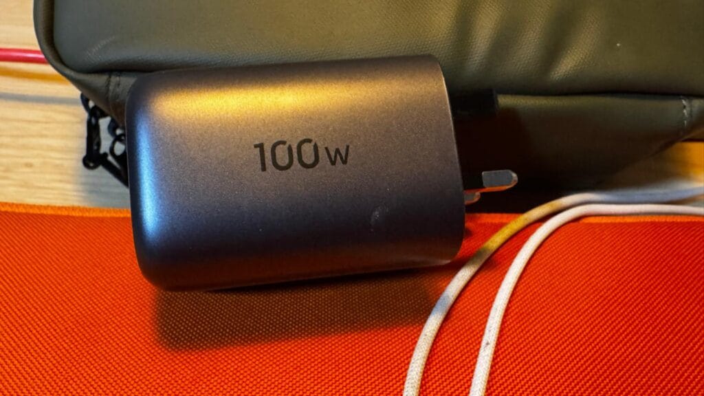 Side view of UGREEN 100W USB‑C GaN charger on desk surface