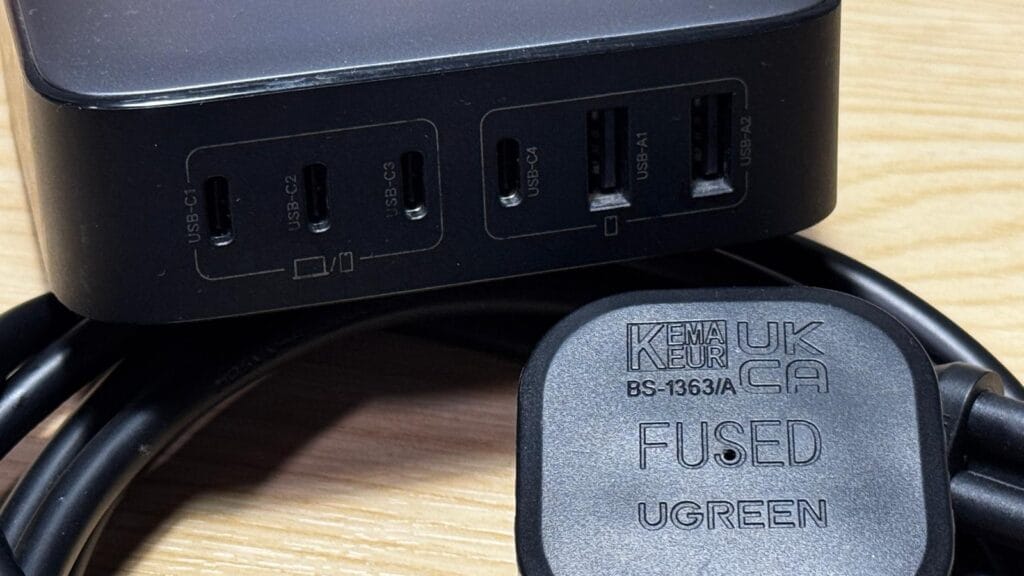 UGREEN 200W GaN desktop charger with UK fused plug and power cable on wooden desk