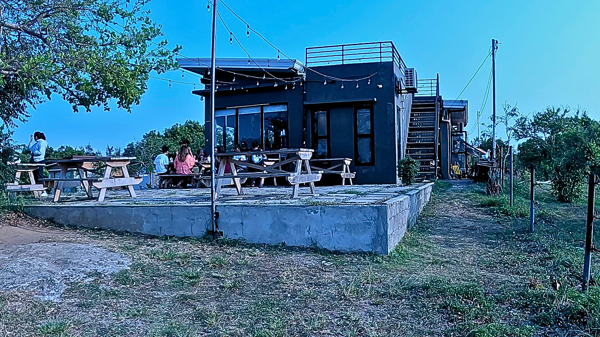 Outdoor picnic tables and the black café building at 18 Degrees North in Bangui.