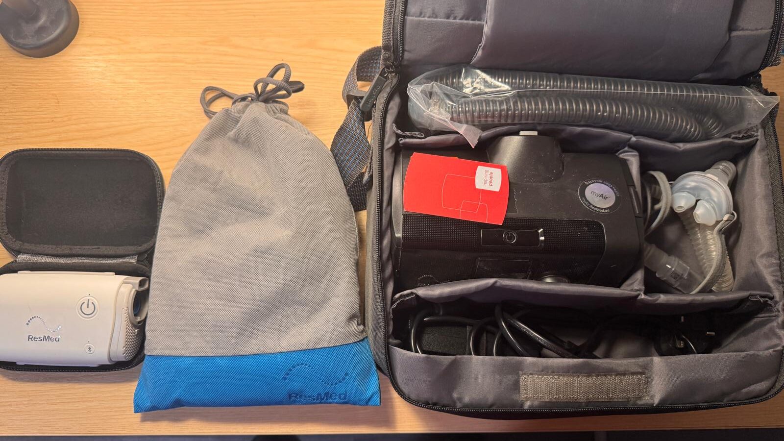 CPAP travel guide kit: ResMed AirMini in its hard case, ResMed drawstring bag and ResMed AirSense 10 packed with hose and mask