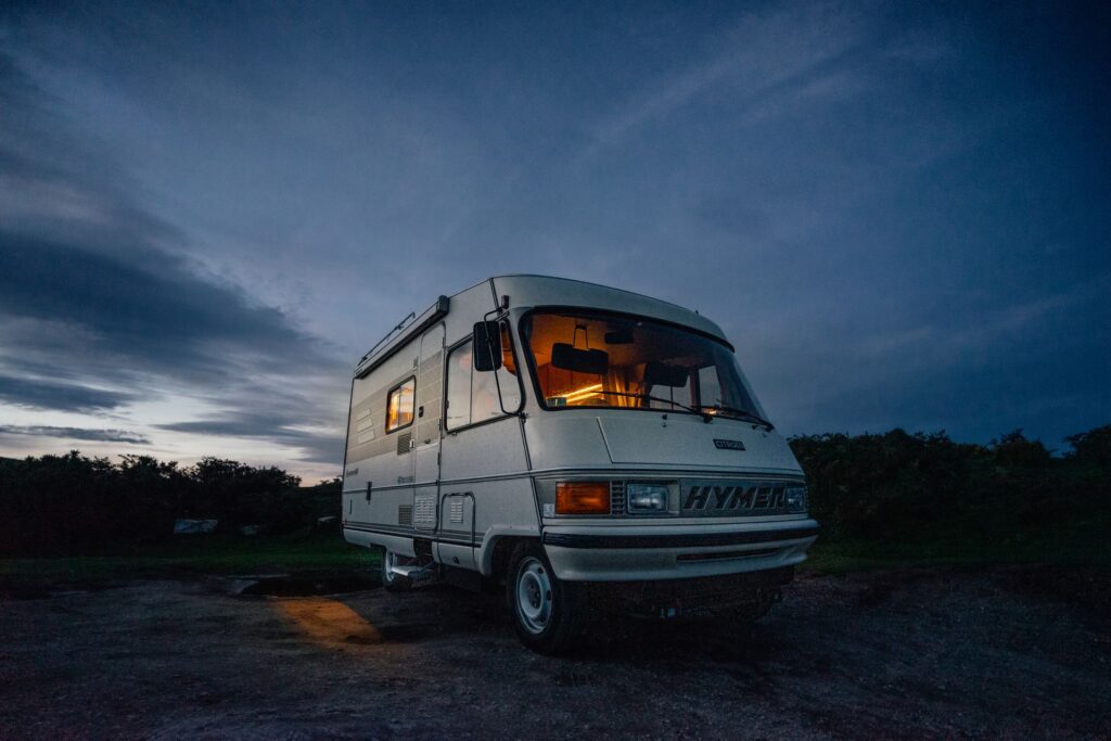 RV Motorhome parked off grid at dusk with its interior lights on