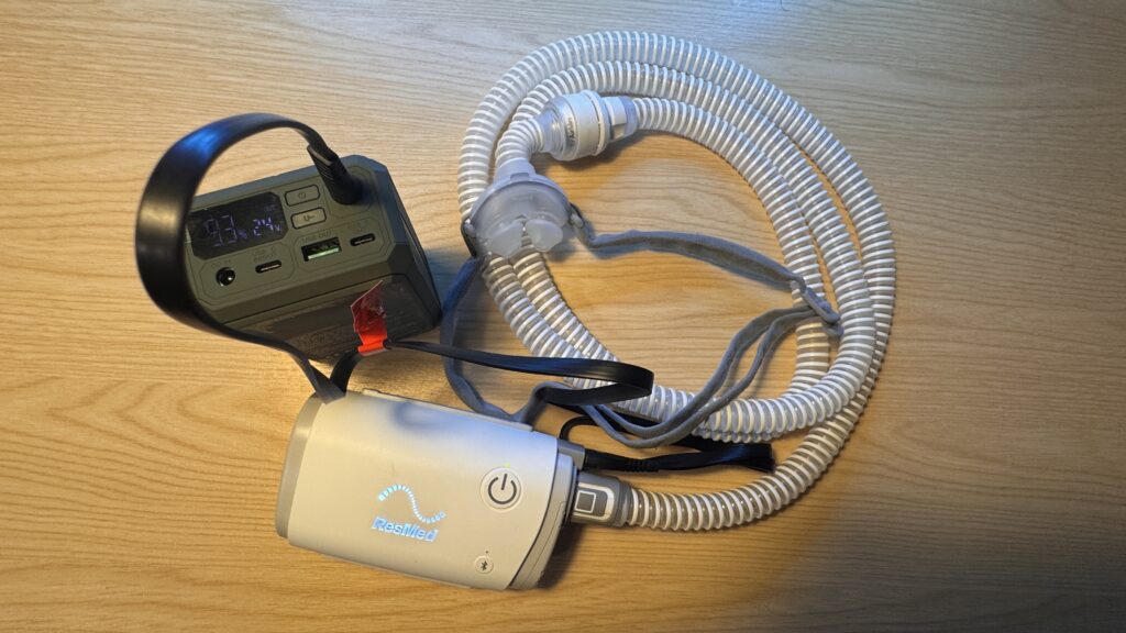 ResMed AirMini running from a travel battery set to 24V, with mask and tubing
